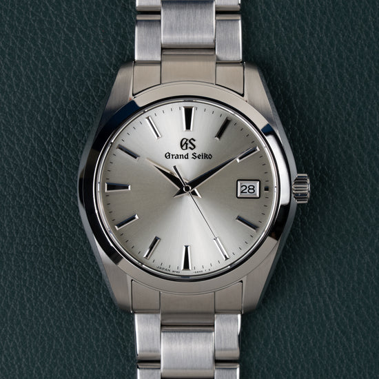 Grand Seiko Heritage Collection SBGV221 - Volledig horloge recht van boven met zilverkleurige wijzerplaat en stalen schakelband