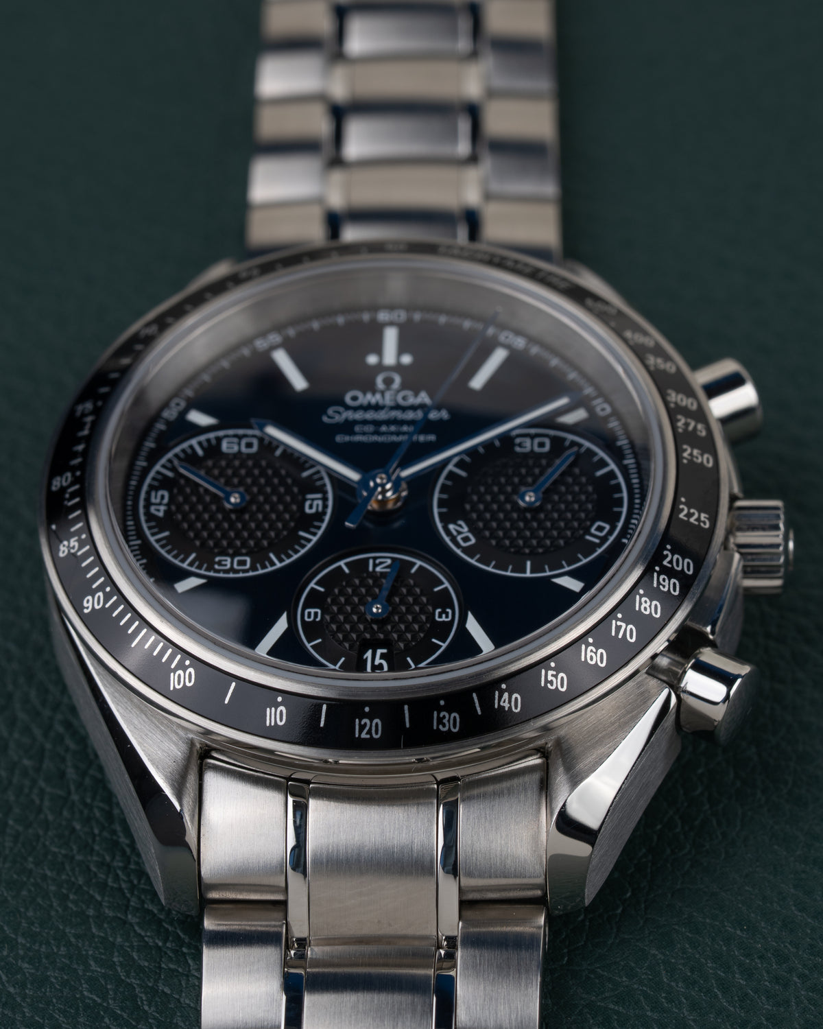Omega Speedmaster Racing 326.30.40.50.03.001 - close-up van de wijzerplaat met tachymeterbezel, kroon en drukkers rechts