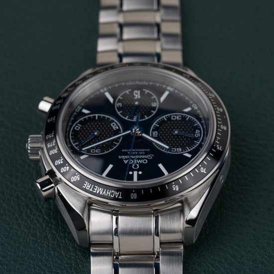 Omega Speedmaster Racing 326.30.40.50.03.001 - ondersteboven aanzicht van de wijzerplaat, kroon en drukkers links