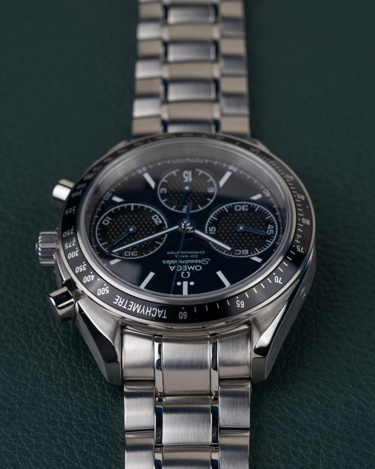 Omega Speedmaster Racing 326.30.40.50.03.001 - ondersteboven aanzicht van de wijzerplaat, kroon en drukkers links