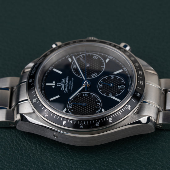 Omega Speedmaster Racing 326.30.40.50.03.001 - rechtstreeks van voren gefotografeerd met kroon en drukkers bovenaan