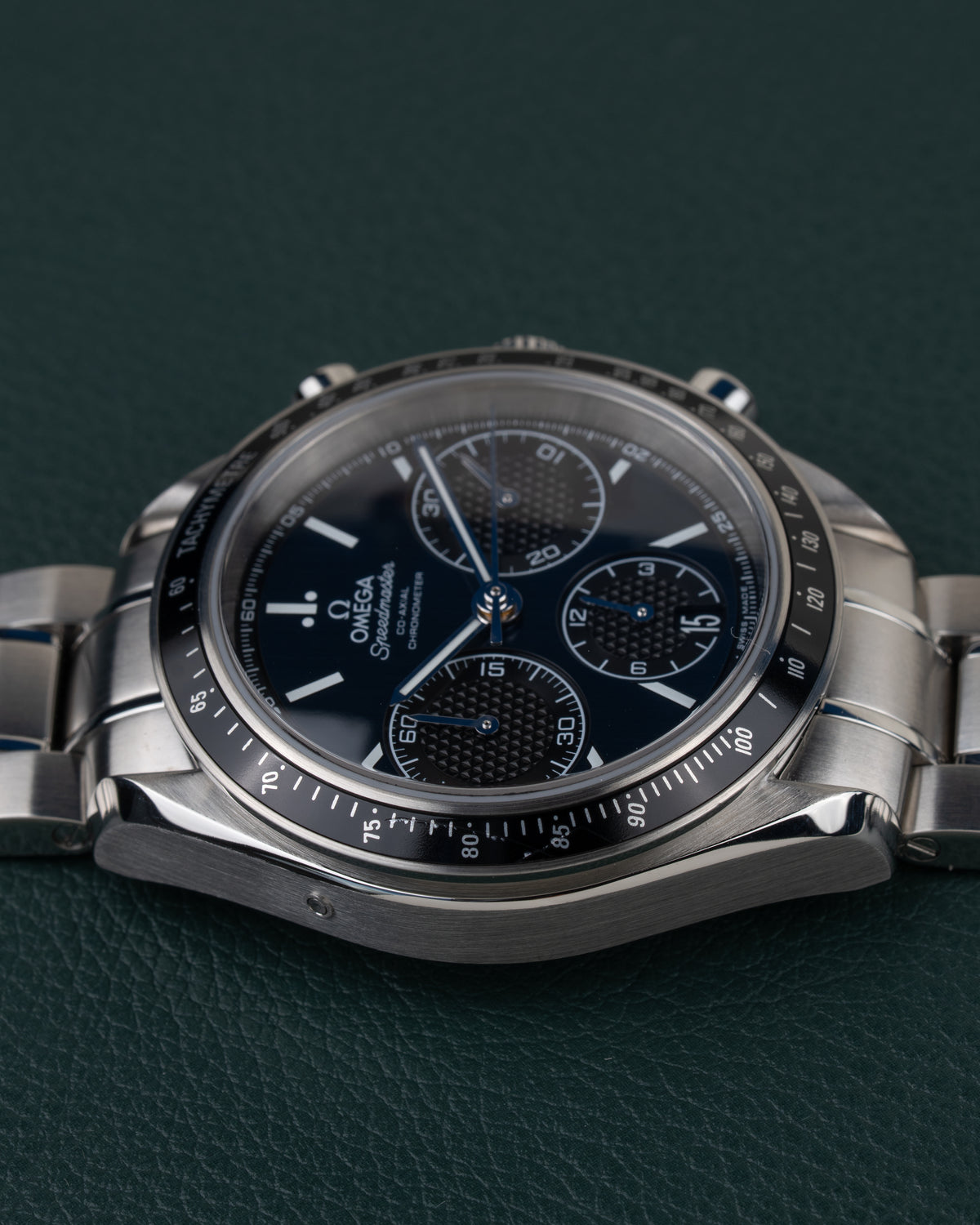 Omega Speedmaster Racing 326.30.40.50.03.001 - rechtstreeks van voren gefotografeerd met kroon en drukkers bovenaan