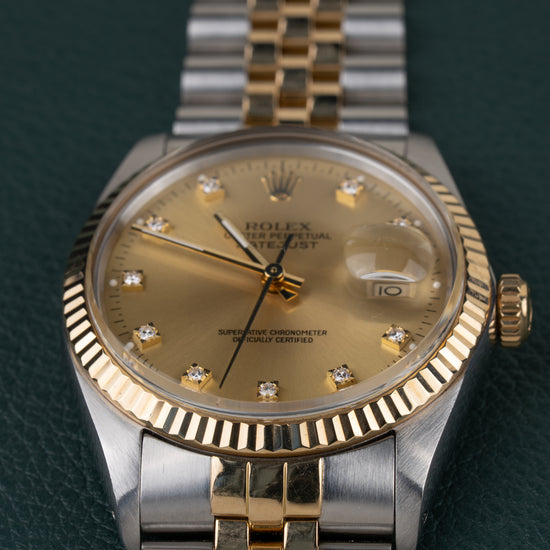 Rolex Datejust 16013 Champagne Diamanten Dial - close-up van de wijzerplaat met gefacetteerde gouden bezel en Cyclops-datumlens