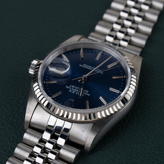 Rolex Datejust 16234 Blue Dial 1991 - Ondersteboven aanzicht onder een hoek met de kroon links en de jubilee-band schuin naar boven rechts