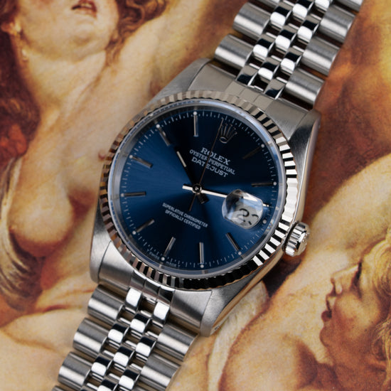 Rolex Datejust 16234 Blue Dial - sfeerfoto van het horloge tegen een klassiek schilderij