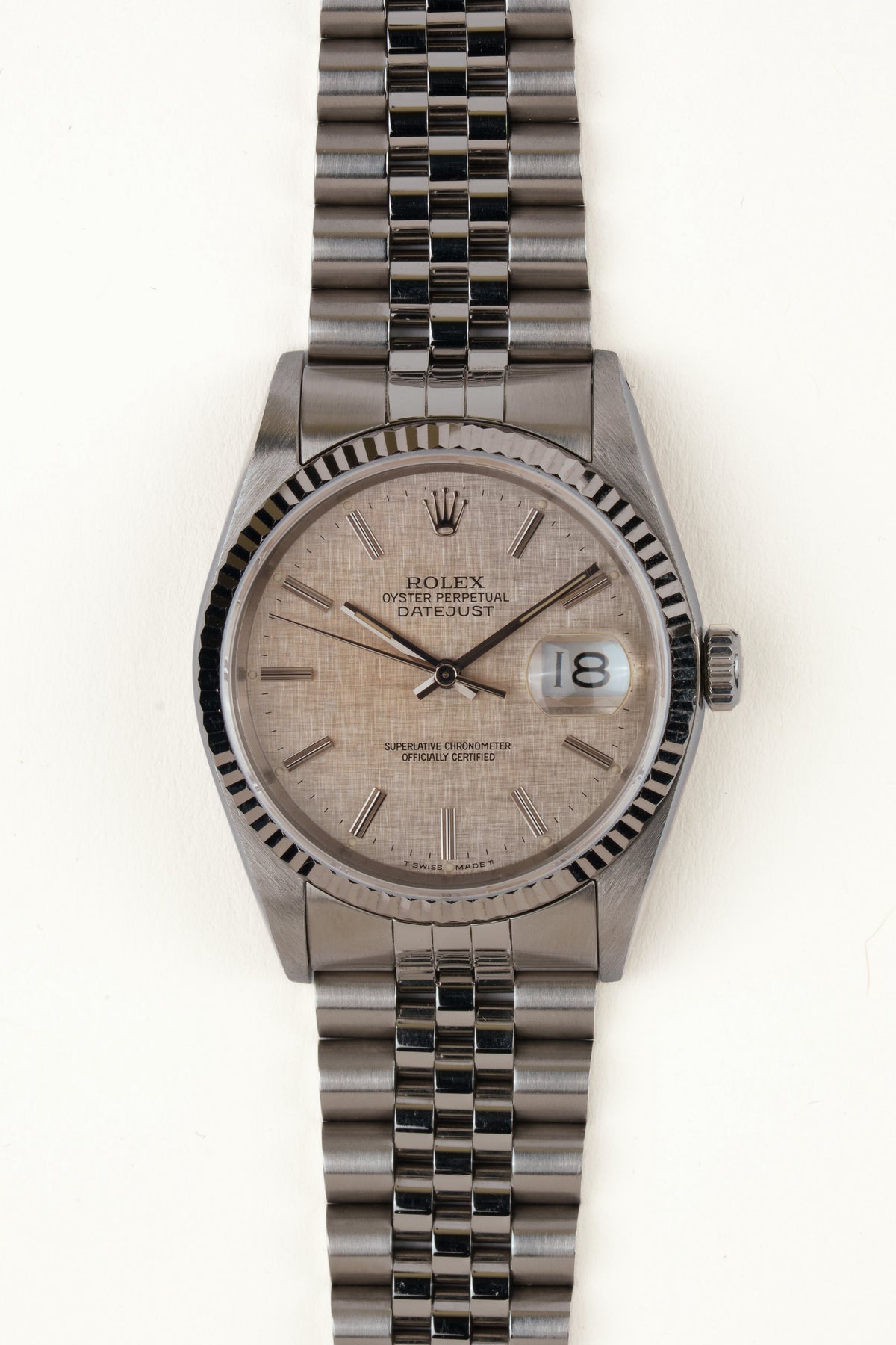 Rolex Datejust 16234 - vooraanzicht van de zilveren wijzerplaat, geribbelde witgouden bezel en armband