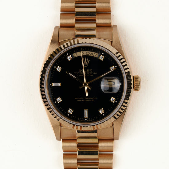 Rolex Day-Date 18038 - vooraanzicht van de zwarte wijzerplaat met diamanten indexen, geribbelde gouden bezel en President-armband