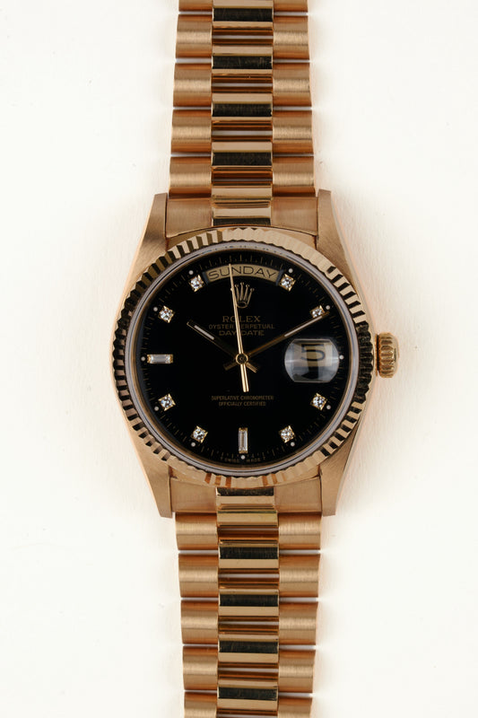 Rolex Day-Date 18038 - vooraanzicht van de zwarte wijzerplaat met diamanten indexen, geribbelde gouden bezel en President-armband